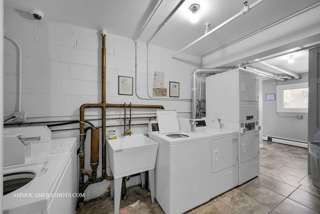 clothes washing area featuring baseboard heating, sink, washer and dryer, stacked washer and clothes dryer, and light tile patterned flooring