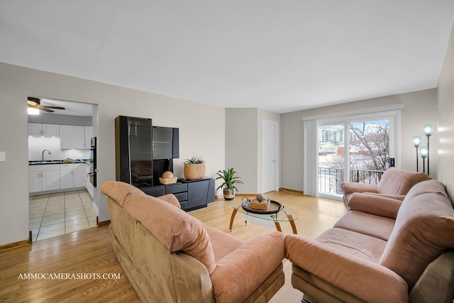 living room with ceiling fan, light hardwood / wood-style floors, and sink