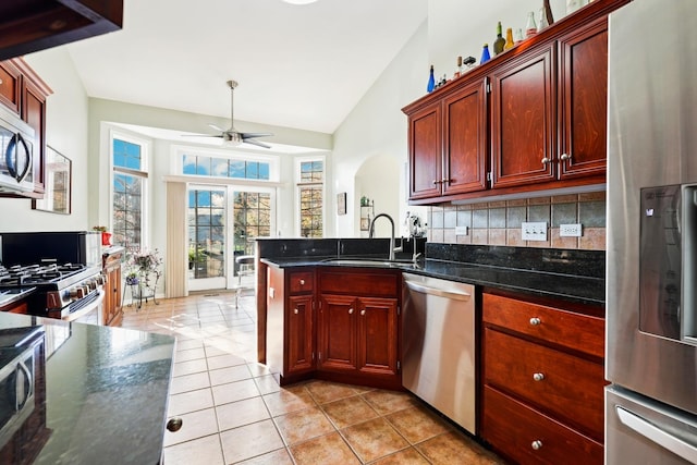 kitchen featuring lofted ceiling, sink, appliances with stainless steel finishes, ceiling fan, and backsplash