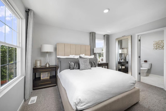 bedroom featuring connected bathroom and carpet floors