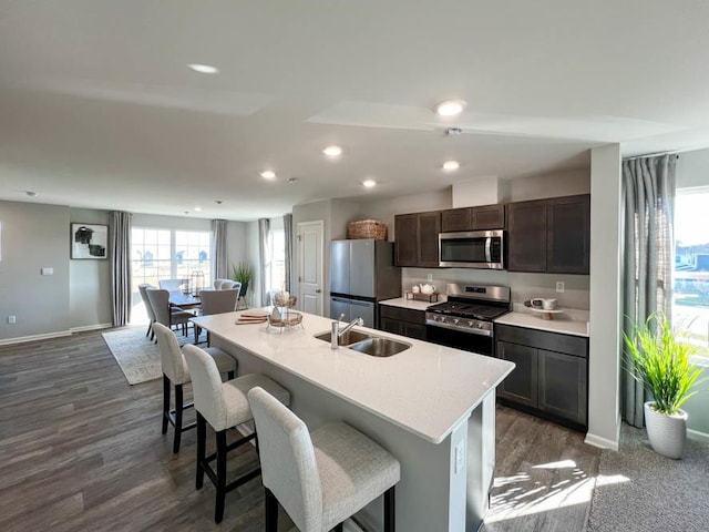 kitchen with a center island with sink, a breakfast bar, sink, and stainless steel appliances