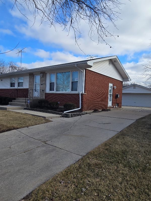 view of front of home with a garage, an outbuilding, and a front yard