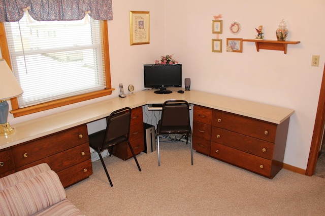 office space with built in desk and light colored carpet