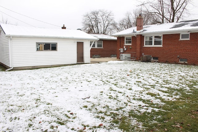 snow covered rear of property with cooling unit