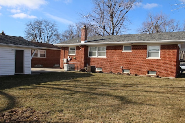 back of house featuring central AC and a lawn