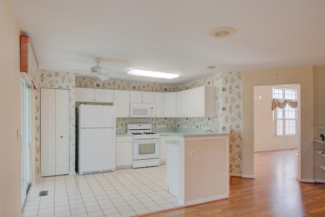 kitchen with ceiling fan, white appliances, light hardwood / wood-style floors, and white cabinets