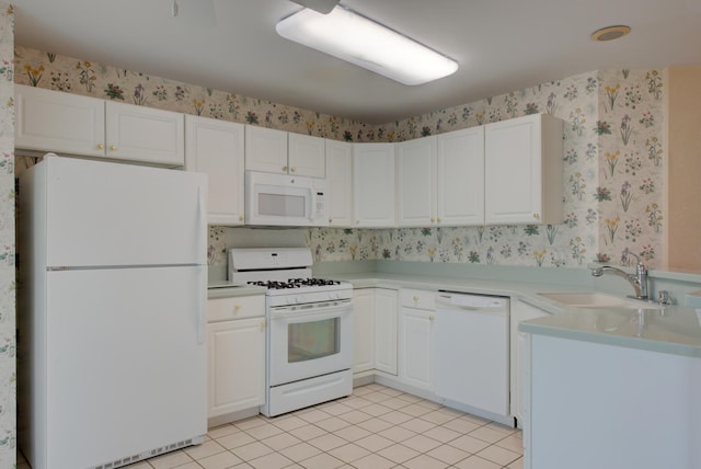 kitchen featuring sink, white appliances, light tile patterned floors, and white cabinets