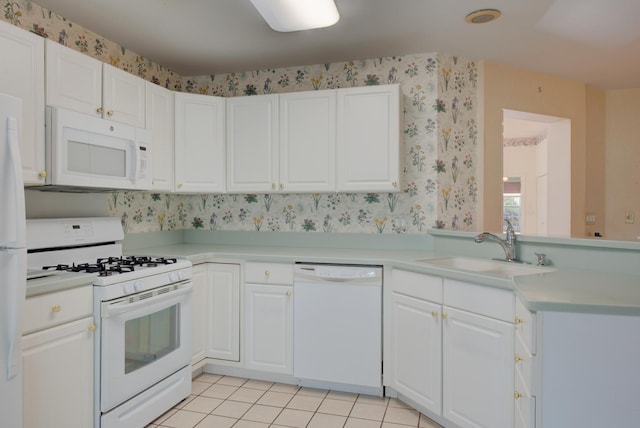 kitchen featuring light tile patterned flooring, sink, white cabinets, and white appliances