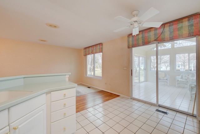 kitchen with white cabinetry, sink, ceiling fan, and light tile patterned flooring