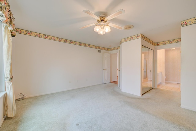 empty room featuring ceiling fan and light carpet