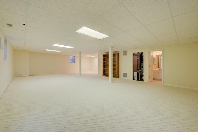 basement featuring carpet and a paneled ceiling