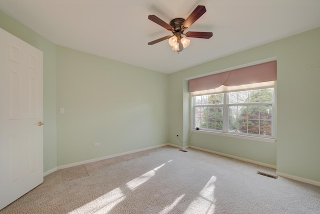 carpeted spare room with ceiling fan