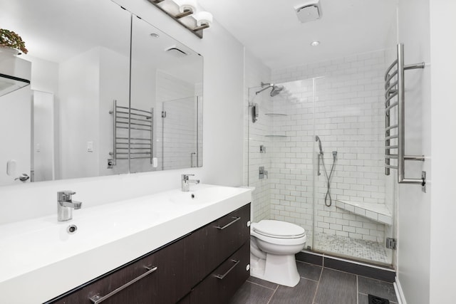 bathroom with vanity, toilet, and a shower with shower door