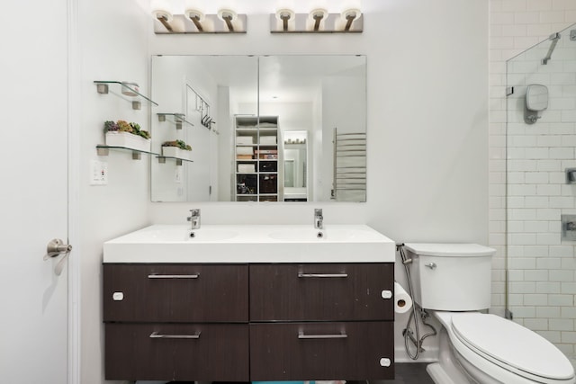 bathroom with vanity, toilet, and a shower with door