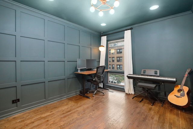 home office with wood-type flooring, ornamental molding, and a chandelier