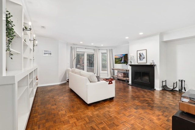 living room featuring dark parquet flooring and crown molding