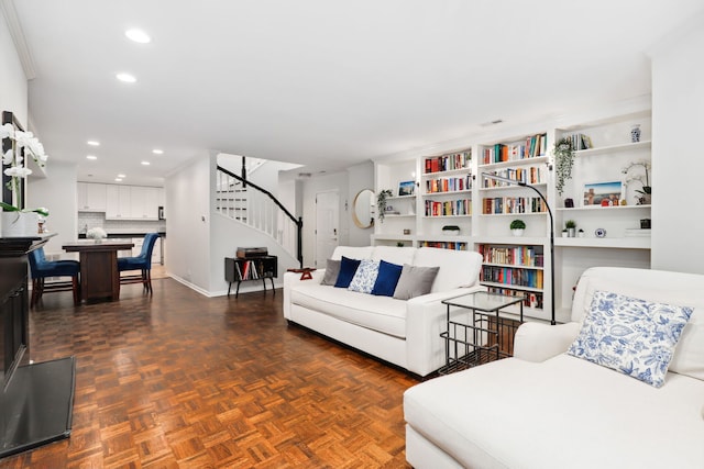 living room featuring dark parquet floors and crown molding