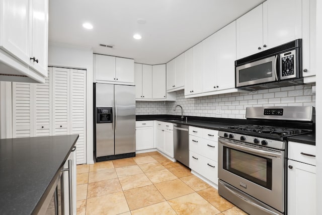 kitchen with white cabinets, sink, decorative backsplash, light tile patterned flooring, and stainless steel appliances