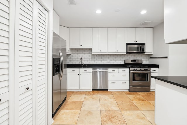 kitchen featuring backsplash, white cabinetry, sink, and appliances with stainless steel finishes