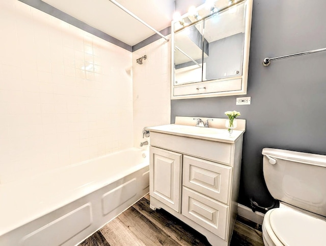 full bathroom with tiled shower / bath combo, toilet, wood-type flooring, and vanity