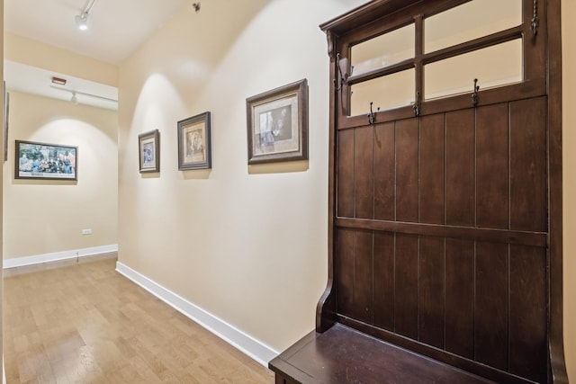 hallway with light wood-type flooring and rail lighting