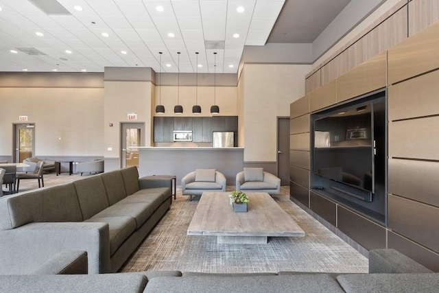 living room with a high ceiling and a drop ceiling