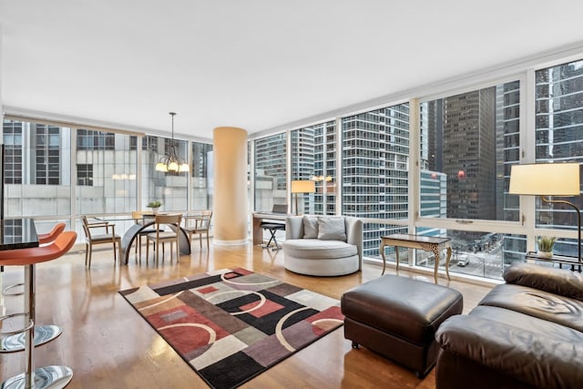 living room with floor to ceiling windows, a notable chandelier, and hardwood / wood-style flooring