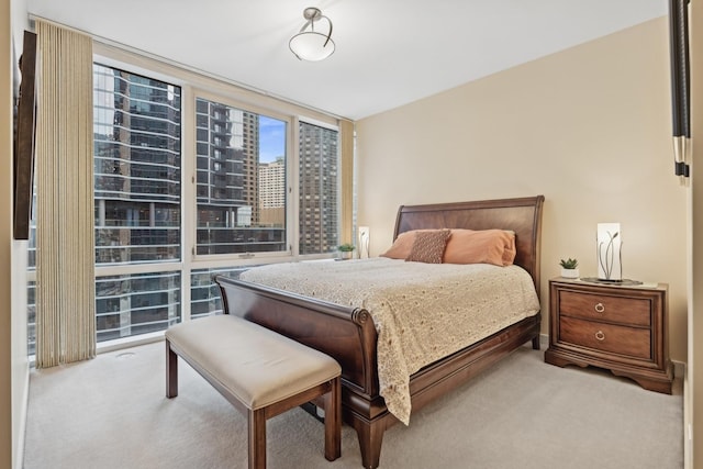 bedroom featuring light colored carpet and a wall of windows