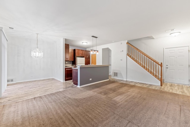 unfurnished living room with carpet and an inviting chandelier