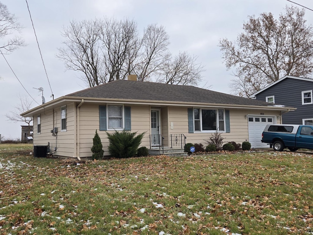 single story home with cooling unit, a garage, and a front lawn