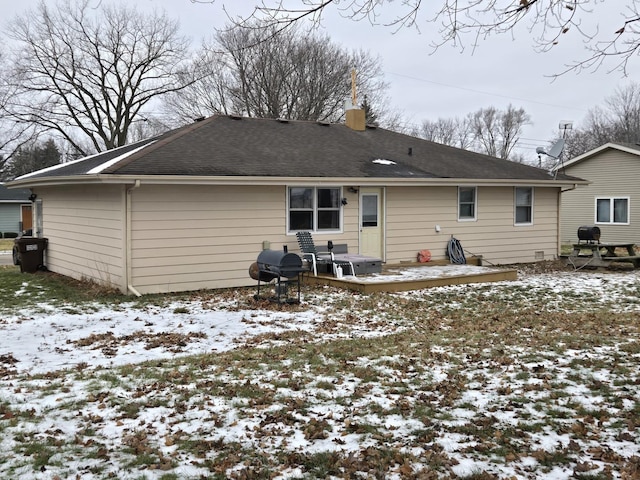 snow covered back of property featuring a wooden deck