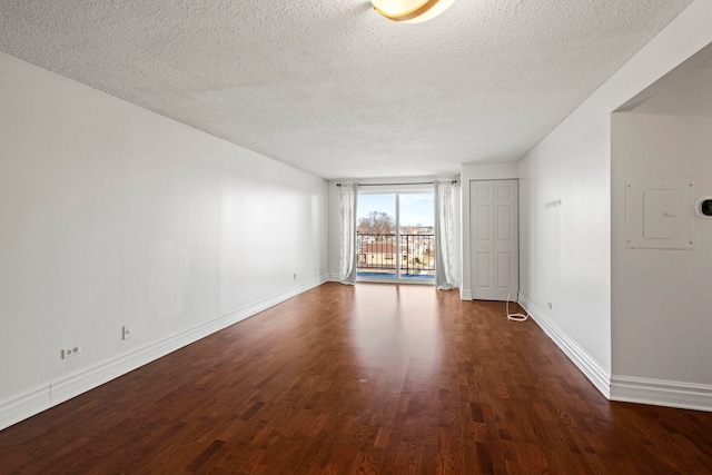 empty room featuring dark hardwood / wood-style flooring and a textured ceiling