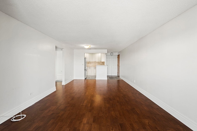 unfurnished living room featuring a textured ceiling and dark wood-type flooring