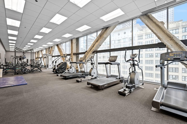 workout area with plenty of natural light and a drop ceiling