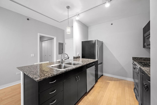 kitchen with pendant lighting, a center island, sink, light hardwood / wood-style flooring, and stainless steel appliances