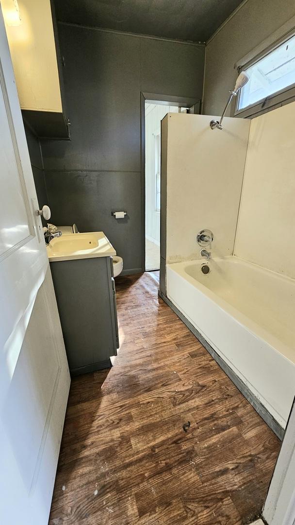 bathroom featuring shower / bathing tub combination, vanity, toilet, and wood finished floors