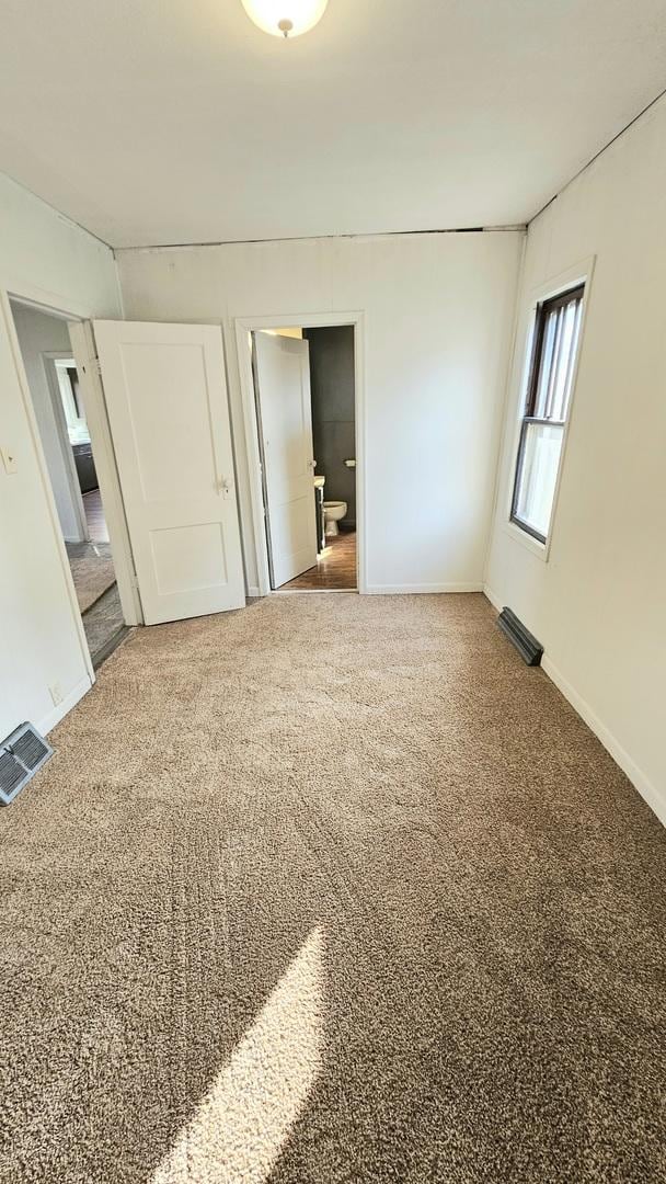 unfurnished bedroom featuring baseboards, visible vents, and carpet flooring