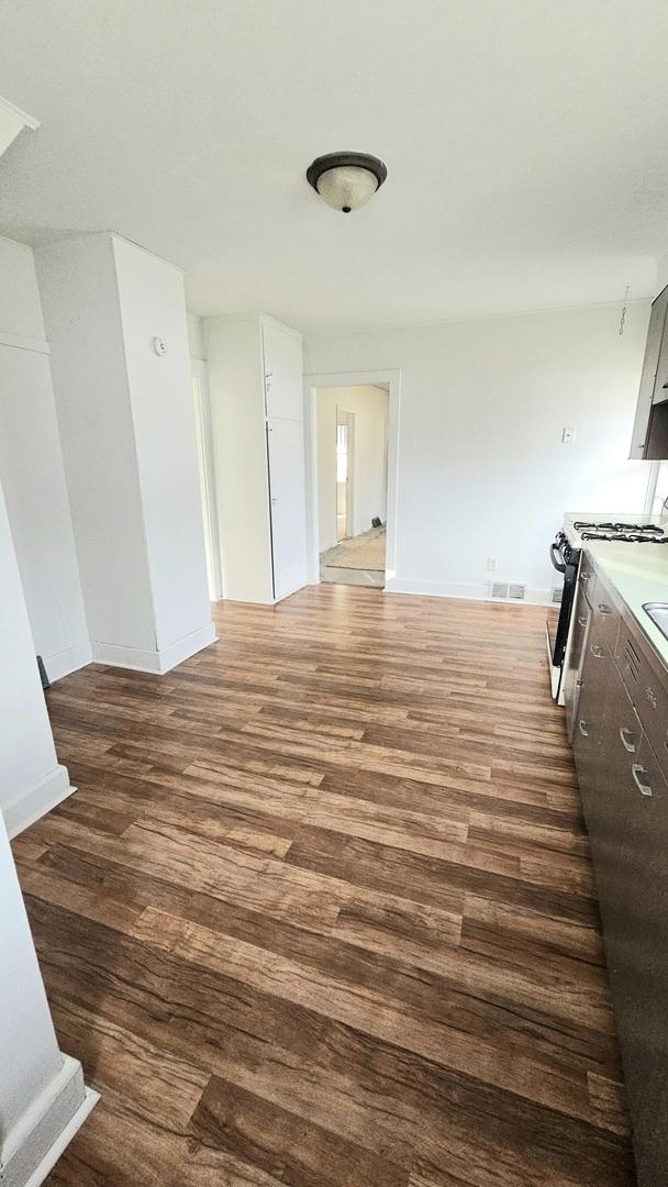 interior space with visible vents, baseboards, and wood finished floors