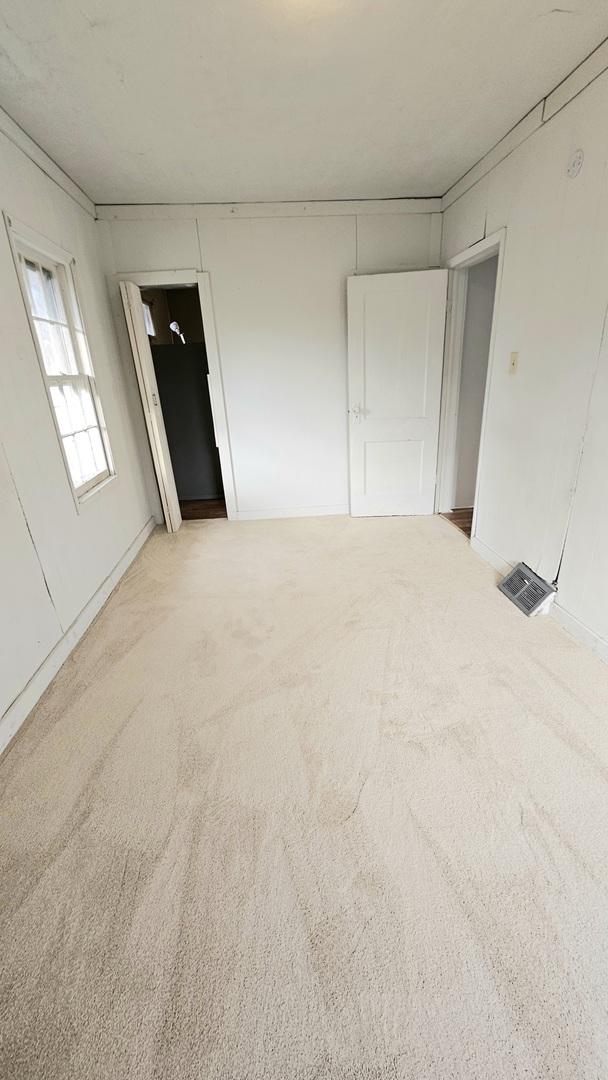 unfurnished bedroom with visible vents and light colored carpet