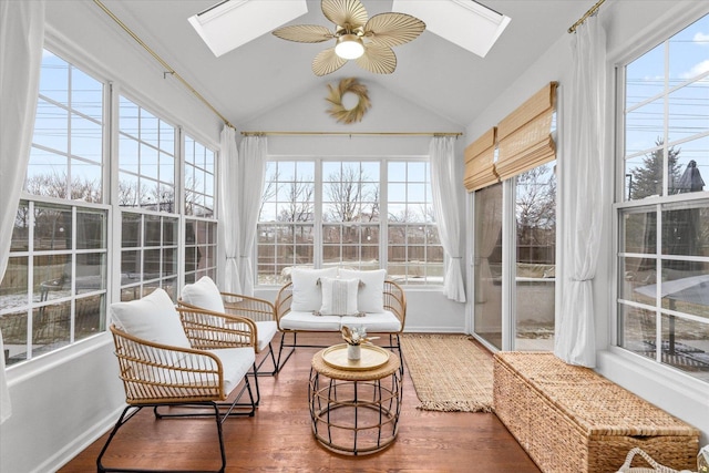 sunroom / solarium with ceiling fan and vaulted ceiling with skylight