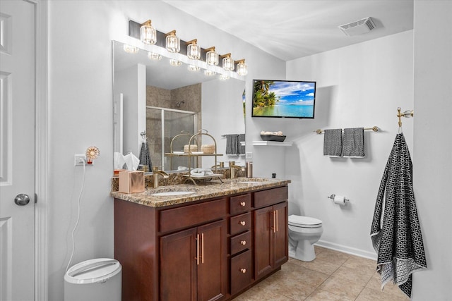 bathroom featuring tile patterned flooring, vanity, toilet, and a shower with shower door