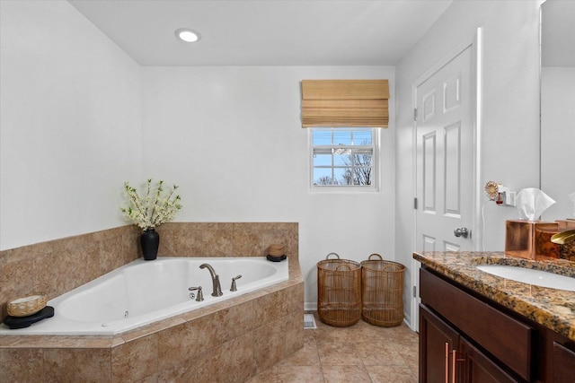 bathroom with vanity and a relaxing tiled tub