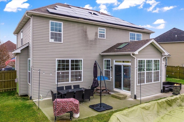 back of house with a patio area and solar panels