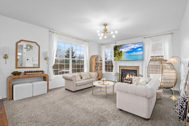 living room featuring carpet flooring, a fireplace, and a notable chandelier