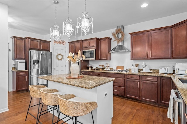 kitchen with a center island, dark hardwood / wood-style flooring, pendant lighting, a chandelier, and appliances with stainless steel finishes