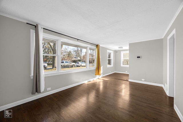 unfurnished room featuring a textured ceiling, dark hardwood / wood-style flooring, and crown molding