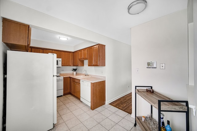 kitchen with sink, light tile patterned floors, and white appliances