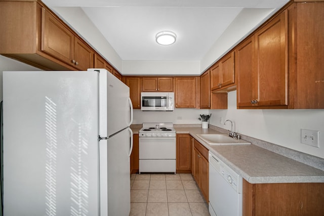 kitchen with light tile patterned floors, white appliances, and sink