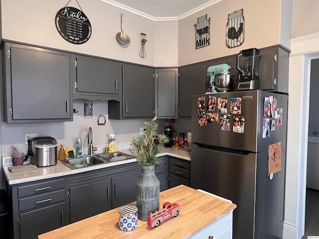 kitchen featuring ornamental molding, sink, gray cabinetry, and stainless steel fridge