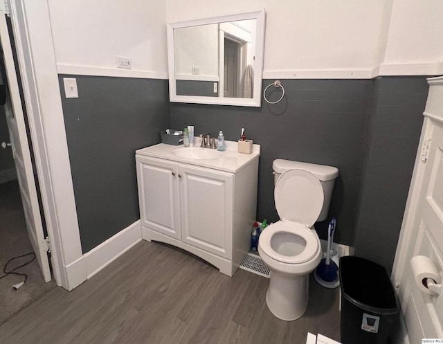 bathroom featuring vanity, hardwood / wood-style flooring, and toilet